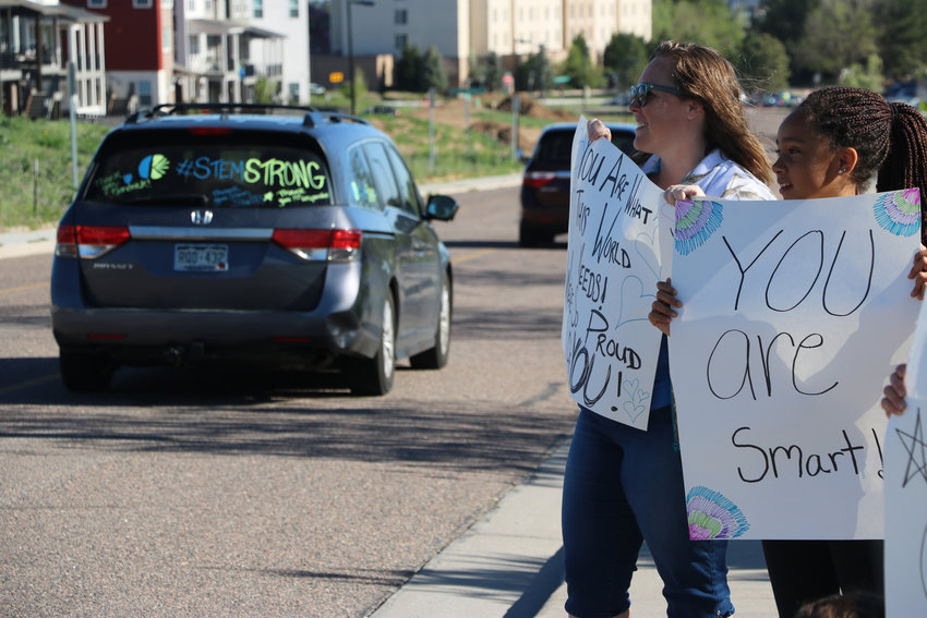Krystal Jensen, left, and her 12-year-old daughter Kierra greet STEM students with words of kindness and encouragement on May 15. It was the first day back for elementary school students after a school shooting on May 7 that killed one student and left eight others injured.